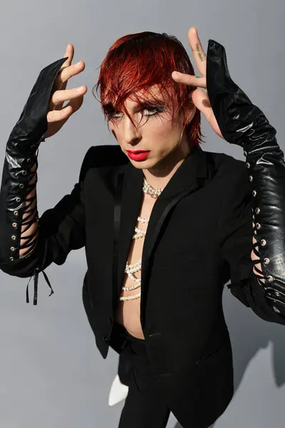 A young man with striking features confidently poses while displaying a bold and fashionable outfit. — Stock Photo