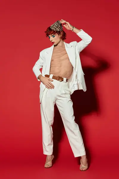 A striking young man wearing a stylish white suit poses confidently with flair. — Stock Photo