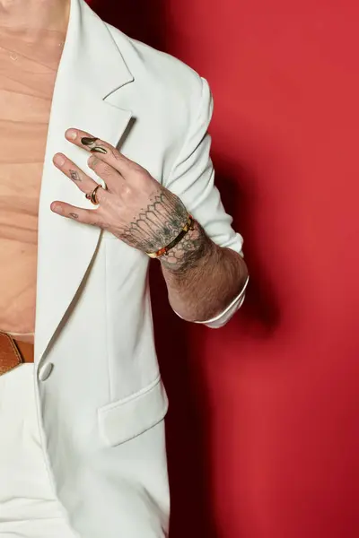 A young man displays his style in a modern suit with intricate tattoos and bold colors. — Stock Photo