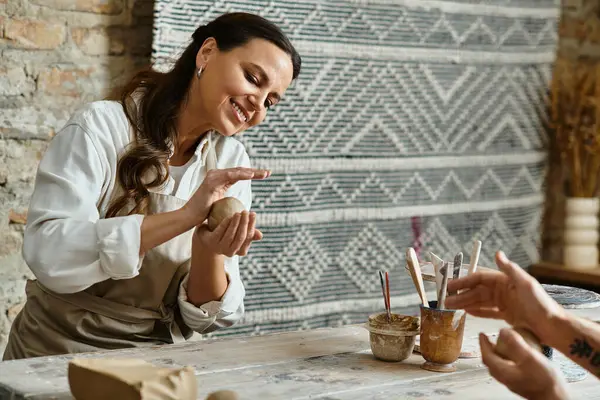 A mature couple enjoys shaping clay together during a pottery class, fostering love and connection. — Stock Photo