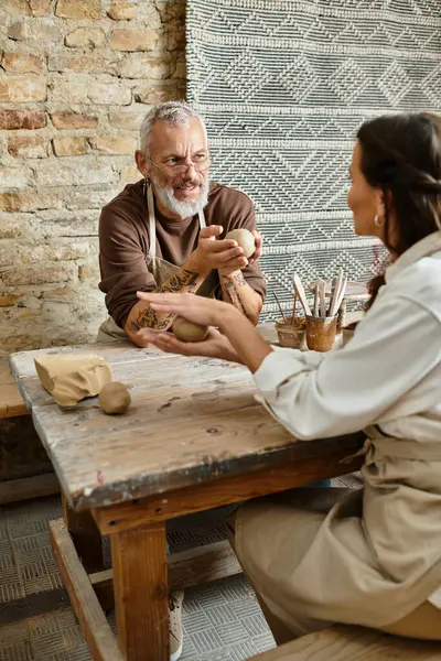 Couple shares a delightful pottery class experience, crafting clay shapes while bonding. — Stock Photo