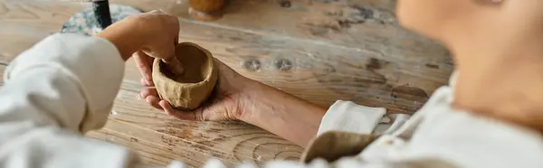 A mature woman enjoys shaping clay in a pottery class, creating memories, banner — Stock Photo