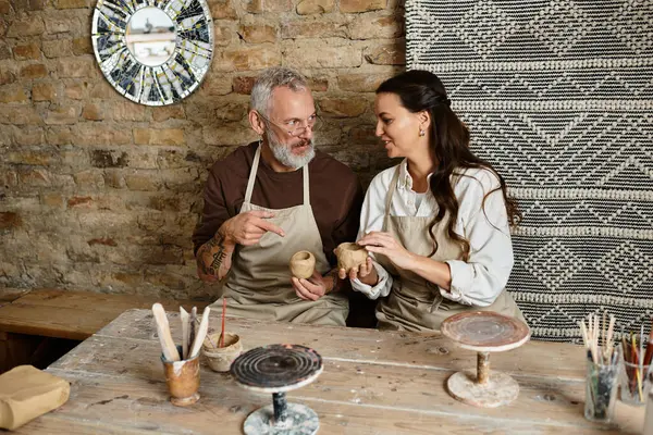 Mature couple enjoys a pottery class, shaping clay and sharing joyful moments together. — Stock Photo