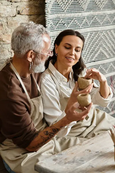 Una bella coppia matura gode di una classe di ceramica, modellando abilmente argilla insieme. — Foto stock