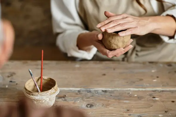 Woman shapes clay in a pottery class, enjoying quality time. — Stock Photo