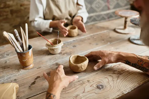 A beautiful mature couple enjoys quality time in a pottery class, shaping clay together. — Stock Photo