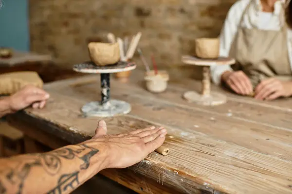 Cropped couple engages in a pottery class, molding clay together while sharing laughter. — Stock Photo