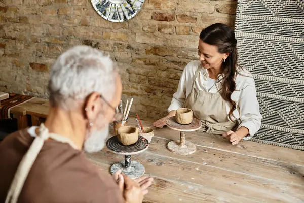 Mature couple enjoys quality time crafting pottery, deeply engaged in their artistic expression. — Stock Photo