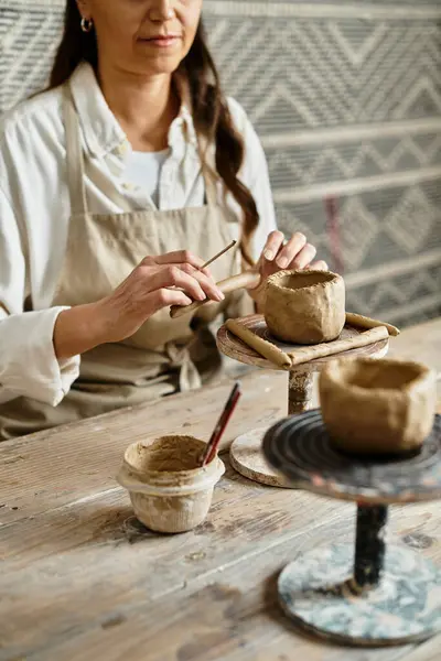 Mature woman enjoys quality time shaping clay in a pottery class, fostering creativity and love. — Stock Photo