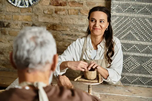 Un beau couple aime façonner l'argile ensemble dans une classe de poterie, approfondissant leur lien. — Photo de stock