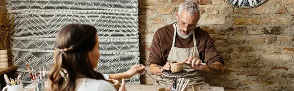 A mature couple enjoys quality time shaping clay in a pottery class, banner — Stock Photo