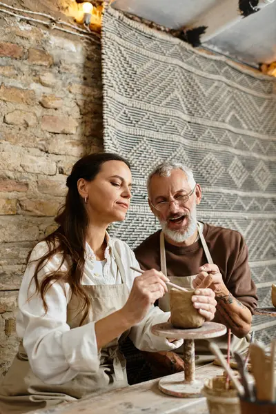 Um belo casal leva tempo para moldar argila em uma classe de cerâmica, desfrutando uns dos outros companhia. — Fotografia de Stock