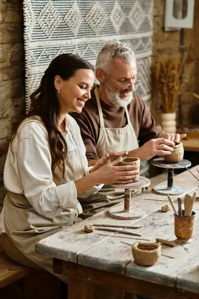 A beautiful couple enjoys shaping clay during a pottery class, sharing quality moments. — Stock Photo