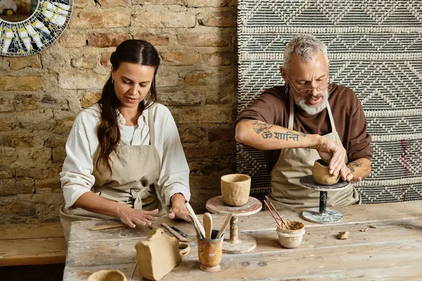 A beautiful couple shapes clay together in a pottery class, enjoying quality time and creativity. — Stock Photo