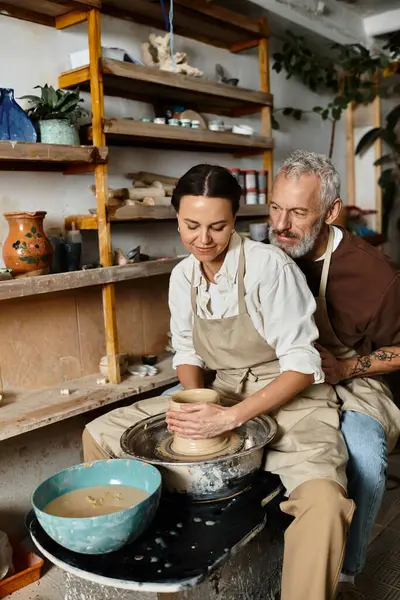A beautiful couple enjoys quality time shaping clay in a pottery class, enhancing their bond. — Stock Photo