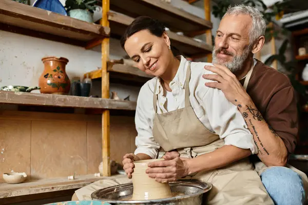 A beautiful couple enjoys a pottery class, shaping clay side by side in a welcoming studio. — Stock Photo