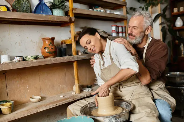 A beautiful couple shares a joyful moment shaping clay in their pottery class, crafting memories. — Stock Photo