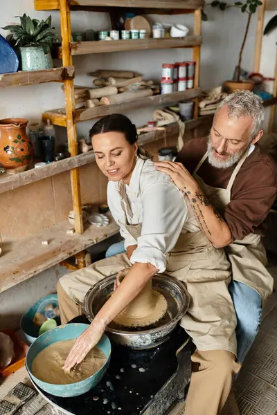 Mature couple joyfully shapes clay together, sharing quality time in a pottery class. — Stock Photo
