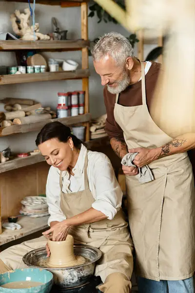 A beautiful couple enjoys shaping clay in a pottery class, sharing quality time and laughter. — Stock Photo