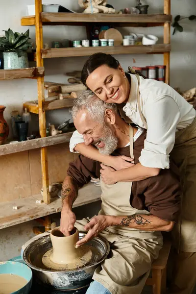 A beautiful couple shapes clay together in a pottery class, enjoying quality time and creativity. — Stock Photo