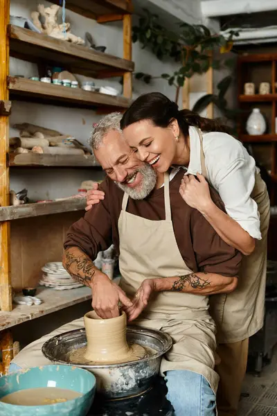 Una pareja madura forma alegremente arcilla juntos en una clase de cerámica, creando recuerdos especiales. - foto de stock