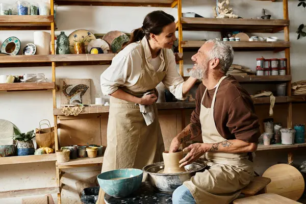 Ältere Paare genießen die Gestaltung von Ton und teilen freudige Momente während eines Töpferkurses. — Stockfoto