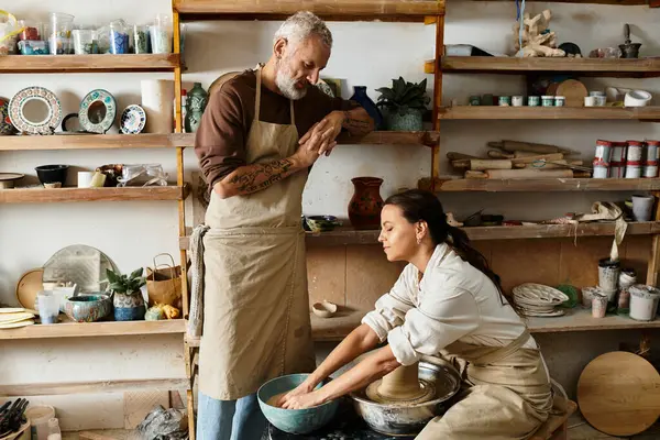 A mature couple enjoys shaping clay together during a pottery class, cherishing quality time. — Stock Photo