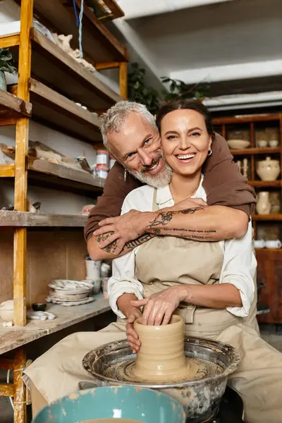 A beautiful couple shares joyful moments while shaping clay during their pottery class. — Stock Photo