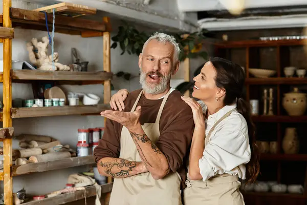 A beautiful mature couple shares laughter and love in a pottery class. — Stock Photo
