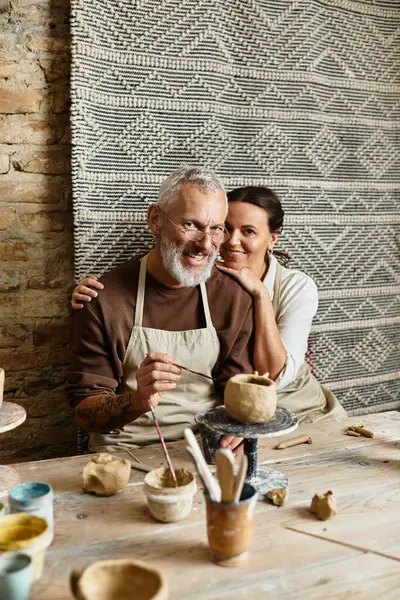 Ein reifes Paar genießt die Zeit, in der es gemeinsam in einem Töpferkurs Ton formt und dabei lacht. — Stockfoto