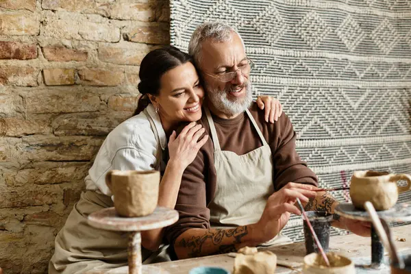 Mature couple enjoys quality time shaping clay in a pottery class, sharing joy and creativity. — Stock Photo