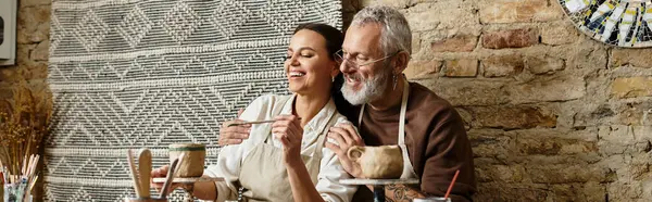 Mature couple enjoys a pottery class while shaping clay, creating meaningful memories together, banner — Stock Photo