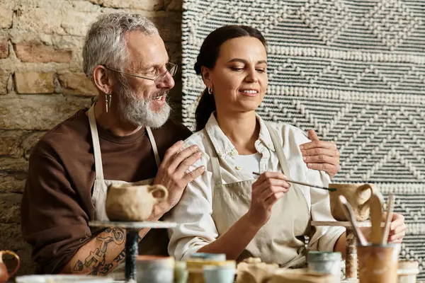 A mature couple shares a joyful pottery class, shaping clay and enjoying quality time together. — Stock Photo
