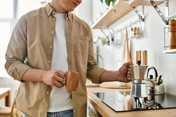 Relaxing at home, the young man prepares a fresh cup of coffee with a cozy atmosphere. — Stock Photo