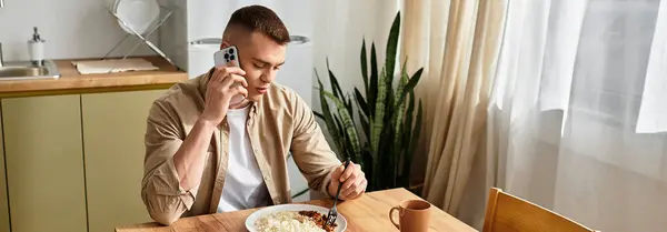 Handsome young man engaged in conversation while enjoying a meal at home in stylish surroundings, banner — Stock Photo
