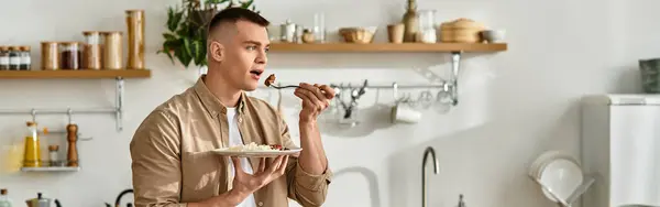 Bello giovane uomo si rilassa nel suo elegante appartamento mentre assapora un delizioso pasto, banner — Foto stock