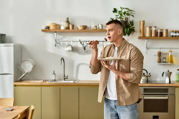 Handsome young man savoring a delicious meal in the comfort of his contemporary home. — Stock Photo
