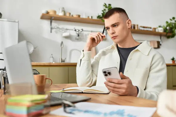 Young man in casual attire works intently from his stylish home setup with a laptop. — Stock Photo
