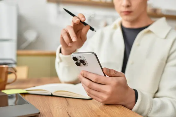 Young man in casual attire is working diligently from his stylish apartment, using a smartphone. — Stock Photo