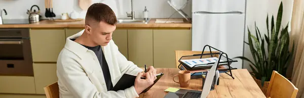 Un bel giovane uomo è concentrato sul suo lavoro freelance in un ambiente elegante home office, banner — Foto stock