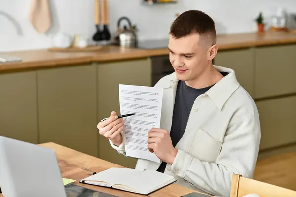 Young man in casual clothes examining printouts while working from home in his apartment — Stock Photo