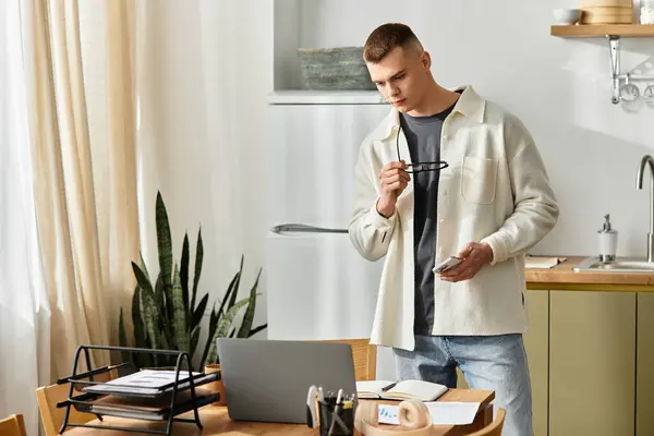 Young man in casual clothes works on freelance tasks at home in his stylish apartment. — Stock Photo