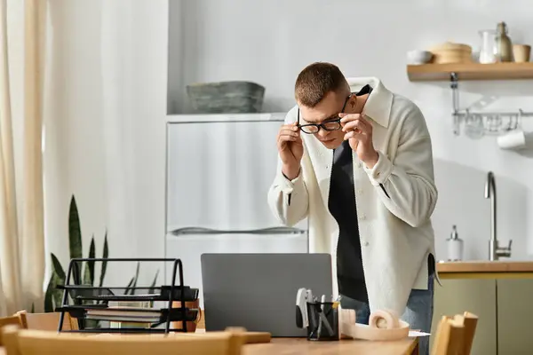 Um homem bonito em roupas casuais trabalha em seu laptop de uma casa moderna. — Fotografia de Stock