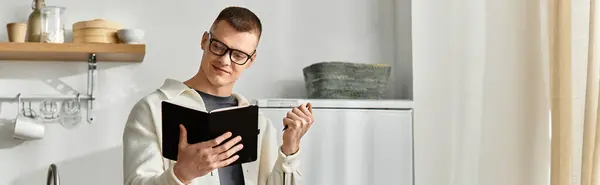 Causal young man enjoys writing in a notebook while surrounded by his modern apartment decor, banner — Stock Photo