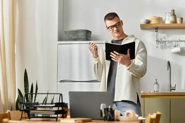 A handsome young man in casual clothes focuses on his work while embracing the comfort of home. — Stock Photo