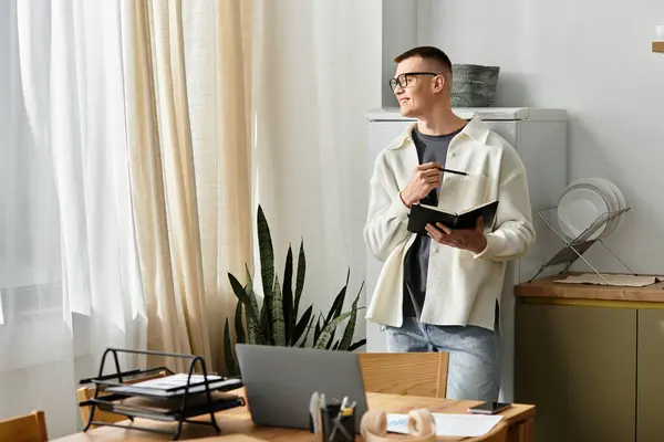 A young man in casual clothes works creatively from his chic apartment, staying focused. — Stock Photo