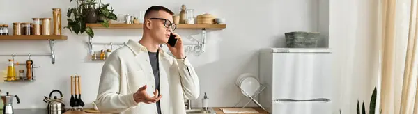 A handsome young man in casual attire talks on his phone while working at home, banner — Stock Photo