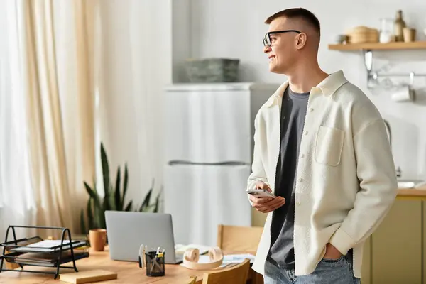 A handsome young man in casual clothes is engaged in remote work at his modern apartment. — Stock Photo