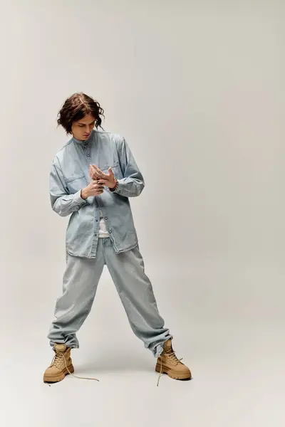 Young stylish man stands confidently in relaxed denim attire, exuding urban fashion vibes. — Stock Photo