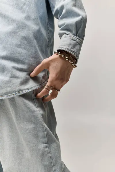 Handsomeness radiates from the young man as he shows off his trendy denim ensemble and accessories. — Fotografia de Stock